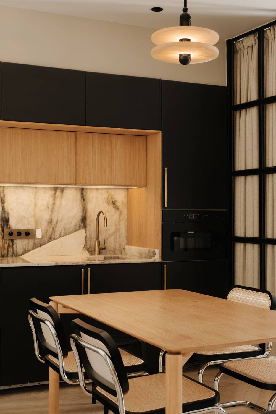 Cuisine noire, marbre veiné et table de six
