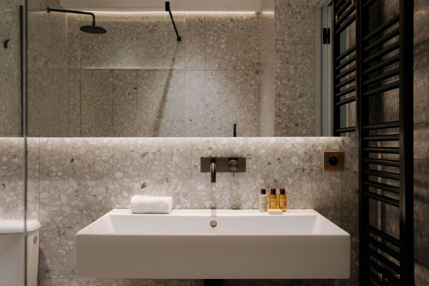 Salle d'eau en terrazzo : vasque et grand miroir