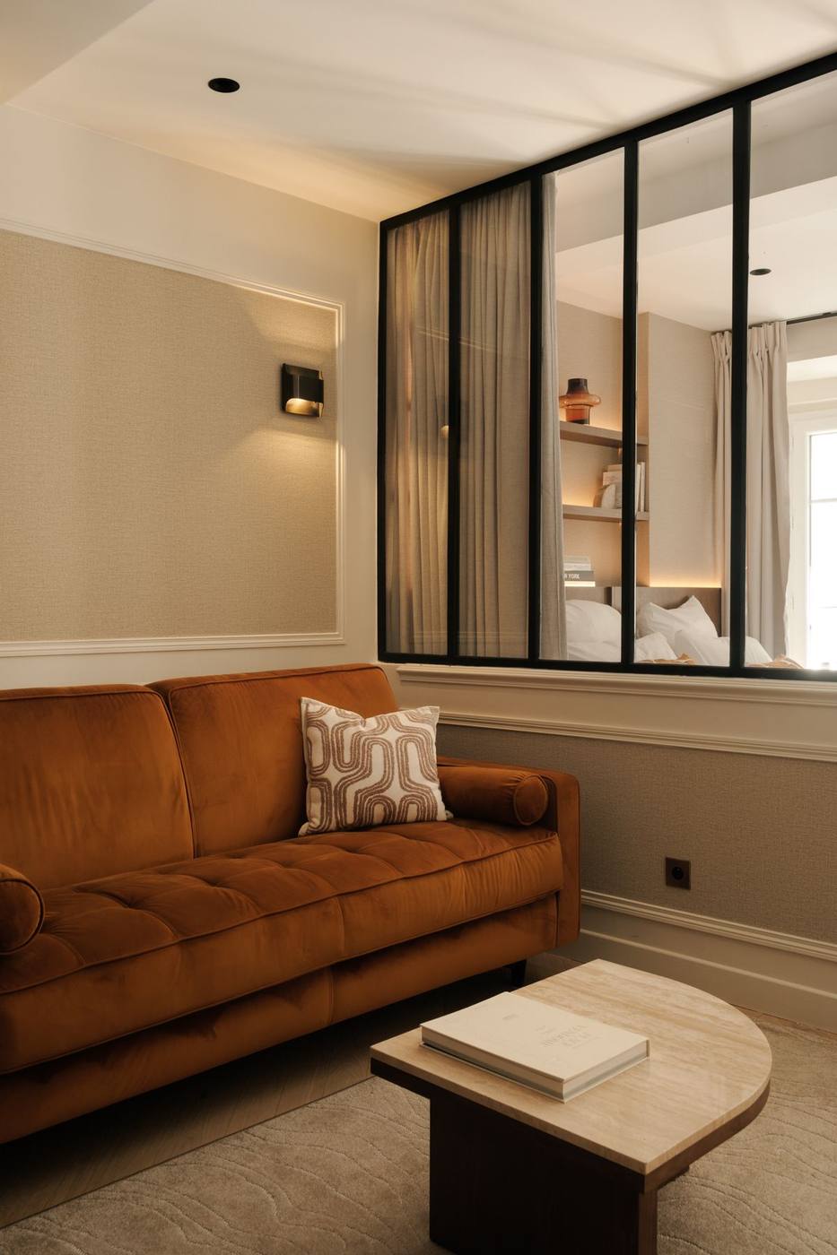 Suite 04 : canapé velours orange et murs habillés de toile