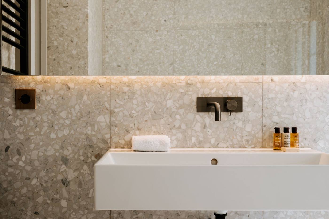 Suite 07 : salle d'eau en terrazzo, vasque et grand miroir